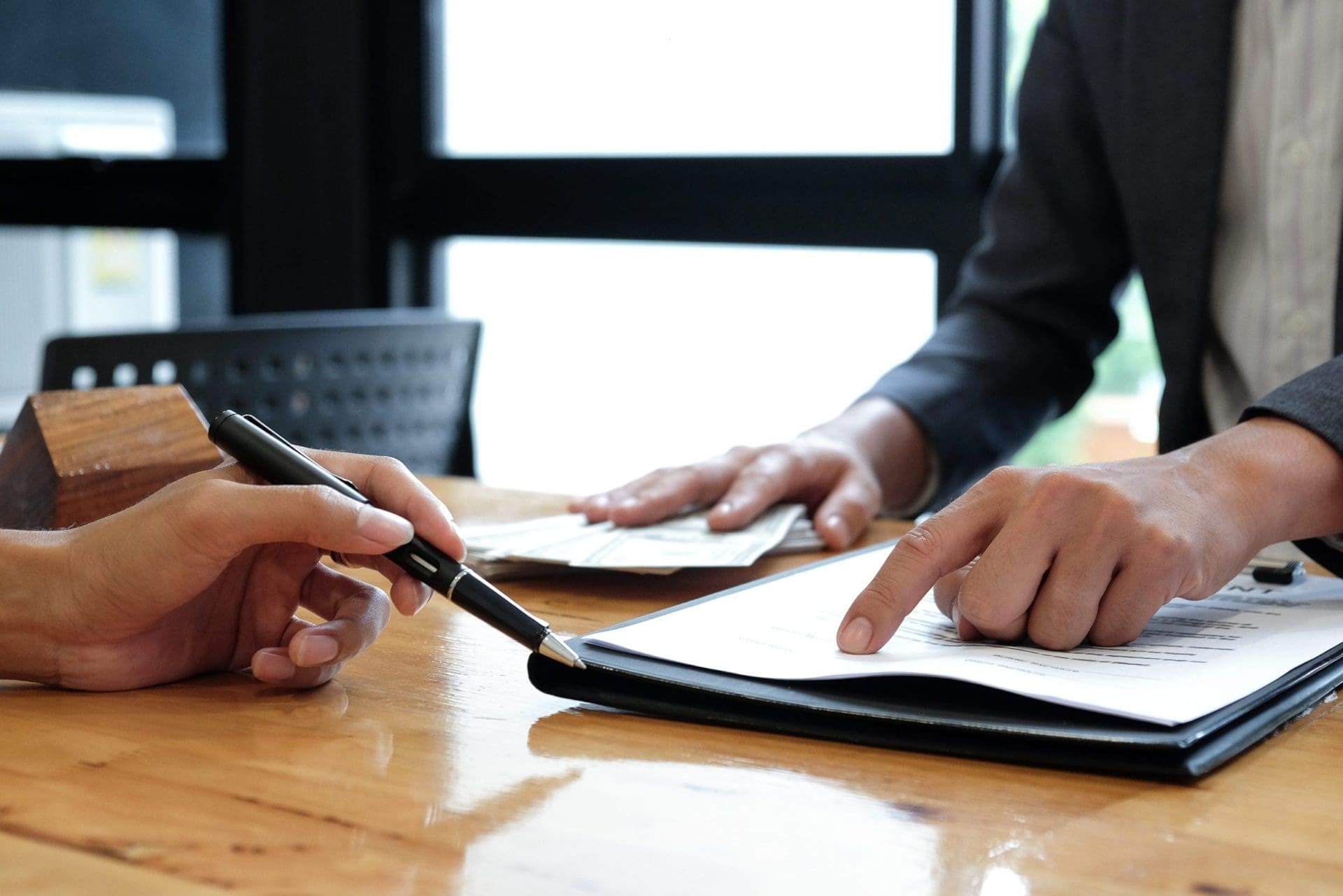 WRLD Two people signing a commercial real estate document at a desk.