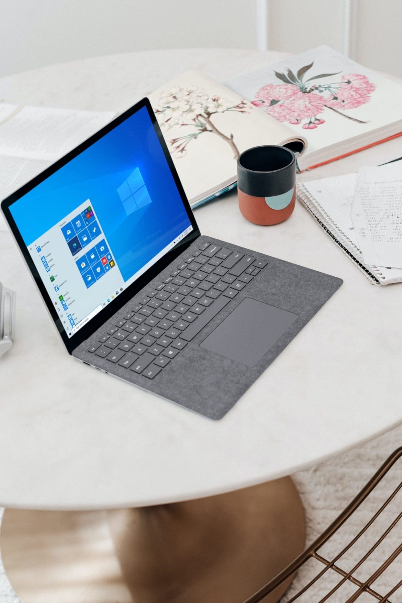 gray microsoft surface laptop computer on white table